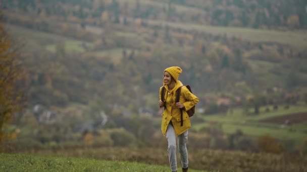 Sarı Yağmurluk Sırt Çantalı Güzel Bir Kadın Tarlalara Dağlara Karşı — Stok video