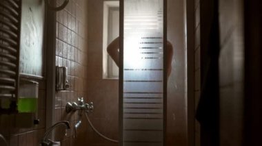 Sinemasız, yüzsüz, şehvetli kadın otel banyosunda, sağlık merkezinde sıcak, rahatlatıcı bir duş alıyor. Kadınlık kavramı, duş alma, kişisel temizlik, spa, özgürlük, cilt bakımı, sağlık hizmetleri.