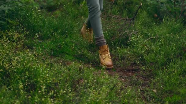 特写女性徒步旅行者穿着老式的黄色远足靴 雨后在潮湿的绿色秋天森林里散步 野生的人 没有脸的人 旅行和度假 假日远足 — 图库视频影像
