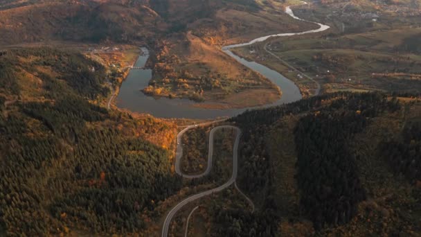 空中无人驾驶飞机俯瞰着蜿蜒的山路 蜿蜒曲折的河流 秋天的乌克兰人 沿着喀尔巴阡山脉的蛇形公路飞行 派递概念 — 图库视频影像