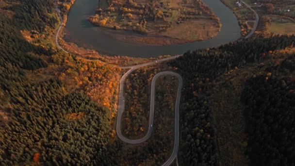 空中无人驾驶飞机俯瞰着蜿蜒的山路 蜿蜒曲折的河流 秋天的乌克兰人 沿着喀尔巴阡山脉的蛇形公路飞行 派递概念 — 图库视频影像