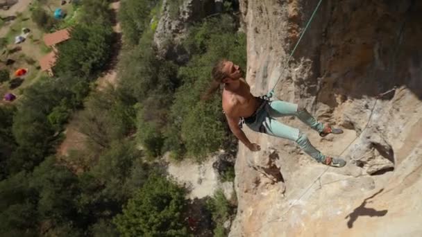 Young Athletic Man Rock Climber Long Hair Climbs Overhanging Cliff — Stockvideo