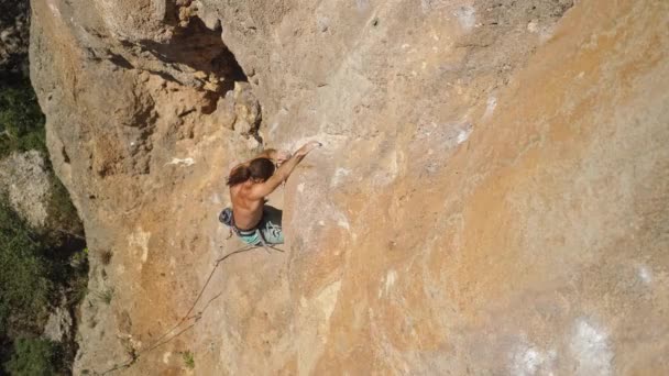 高瞻远瞩年轻强壮的攀岩运动员通过具有挑战性的路线爬上悬崖峭壁 男人爬得很辛苦 做了很长时间的运动 极限运动 户外攀岩 — 图库视频影像