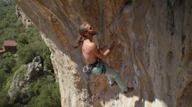 Kas yığını kaya tırmanışçısı sarkık kayalıklara tutunuyor, ellerini tebeşirliyor ve Türkiye 'nin büyük kaya duvarındaki zorlu rotasında bir sonraki aşamaya geçmeye hazırlanıyor. 4k ağır çekim