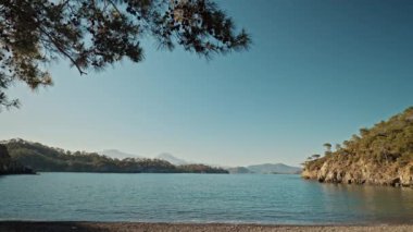 Türkiye 'de Akdeniz kıyısındaki kayalıkları olan ıssız, vahşi plajlarda gündoğumu mavisi gökyüzü ve güzel turkuaz deniz suyu. Yaz tatili, turizm ve doğa güzelliği
