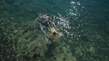 Yeşil mayo giymiş seksi, zayıf kadının 4 km yavaş çekim görüntüleri Akdeniz 'in berrak turkuaz suyuyla kıyıya yüzüyor. Tatil ve sağlık, Yaz Turizm Sezonu Fethiye, Mugla Türkiye