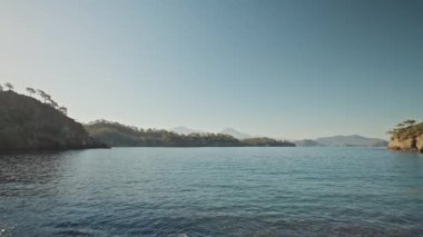 panoramic view of beautiful calm turquoise sea water at wild solitary pebble beach with cliffs at coast of mediterranean sea in Turkey. summer vacation, tourism and nature beauty