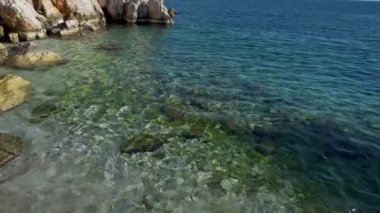 Türkiye 'nin Marmaris kentindeki kayalık kıyılarda Akdeniz' in berrak türkülü sularının geniş manzarası. Yaz mevsimi, turizm sezonu, güzel Türk tatil beldeleri.