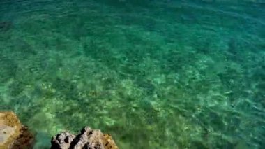 Türkiye 'nin Marmaris kentindeki kayalık kıyı şeridinde Akdeniz' in berrak türkülü sularının geniş manzarasını kapatın. Yaz mevsimi, turizm sezonu, güzel Türk tatil beldeleri.