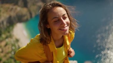 4k slow motion happy traveler freedom filling woman with open arms smiling and enjoying sea coast view, summer journey vacation in Butterfly valley,Turkey. girl stands on top of cliff over sea