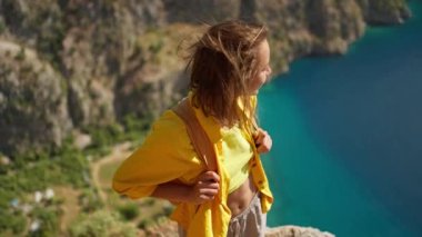 4k slow motion happy traveler freedom filling woman with open arms smiling and enjoying sea coast view, summer journey vacation in Butterfly valley,Turkey. girl stands on top of cliff over sea