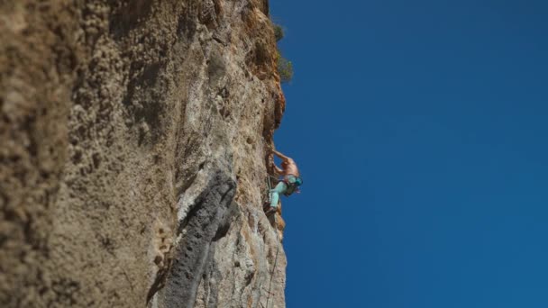 年轻有力的攀岩运动员 长发爬上悬崖峭壁 男人爬得很辛苦 做了很长时间的艰难动作 极限运动 户外攀岩 训练时刻 — 图库视频影像