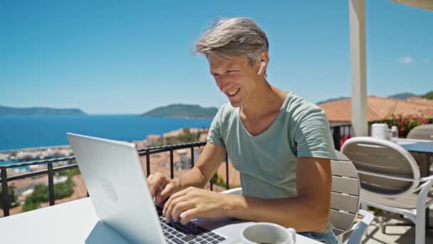 성인이 남자는 노트북 컴퓨터로 아름다운 해수욕장에서 일하면서 메시지를 보내는 이메일을 — 비디오