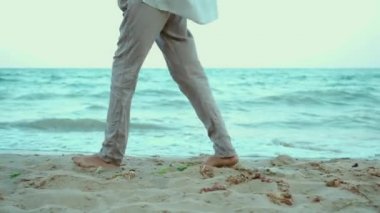 Sıcak güneşli bir akşamda dalgalarla deniz suyunda yürüyen, akıcı beyaz gömlekli, güzel bir yaz kadını. Özgürlük ve cennet kavramı