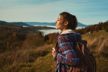 Outdoors portrait young happy woman with backpack admiring beautiful landscape, hiking on mountain ridge