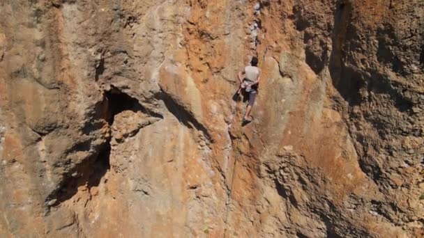 空中慢动作后视镜人类攀岩者爬上悬崖峭壁 男人用Kneebar的果酱在墙上休息和剪断绳子 户外运动和生活方式 — 图库视频影像