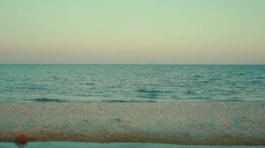 Deniz mavisi denizi, kumlu sahil şeridi ve berrak günbatımı gökyüzü ile sakin minimalist bir manzara. Ukrayna 'da Karadeniz kıyısında. Adanın yaz cenneti