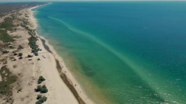 Issız adaya rüya gezisi. Güzel kumsala açık hava macerası. Sinematik vahşi doğa hava 4K. Şeffaf yeşil deniz suları. Ukrayna 'nın güneşli yaz gününde dokunulmamış doğa