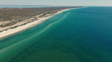 Issız adaya rüya gezisi. Güzel kumsala açık hava macerası. Sinematik vahşi doğa hava 4K. Şeffaf yeşil deniz suları. Ukrayna 'nın güneşli yaz gününde dokunulmamış doğa