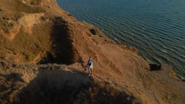 Luftaufnahme Von Mann Touristischen Drohnenpiloten Fuß Auf Gefährlich Dünnen Lehmrücken — Stockvideo