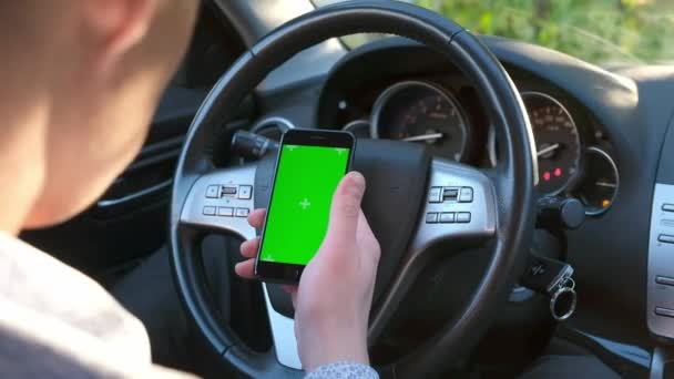 Homem segurando na mão telefone celular em carro.Chroma chave touchscreen mock-up. Conceito: Navegador, entrega, compras on-line, pesquisa na internet. — Vídeo de Stock