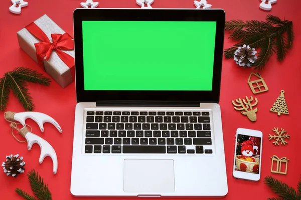 Laptop Zielonym Ekranem Telefon Komórkowy Dekoracje Świąteczne Czerwonym Tle Koncepcja — Zdjęcie stockowe