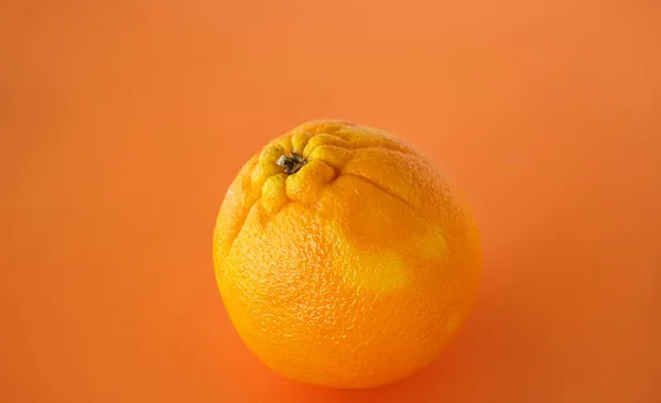 Uma Grande Laranja Madura Com Casca Áspera Fundo Laranja Foco — Fotografia de Stock