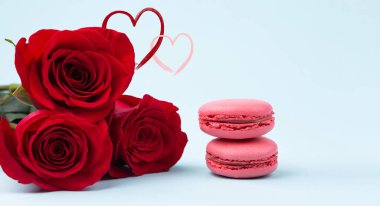 Sevgililer Günü geçmişi. Kırmızı güller ve pastel mavi sanat kağıdında Fransız makarnası. Aşk konsepti: sevgililer günü, doğum günü, düğün, kadınlar günü. Pankart. Uzayı metin için kopyala. Kapat.