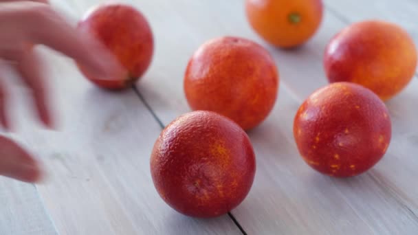 女人的手在木制背景上切下成熟多汁的西西里血红色橙子。季节性的水果。特写。概念：有机水果、健康食品. — 图库视频影像