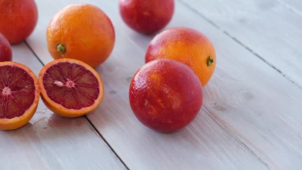 成熟多汁的西西里血红色橙子在木制背景上切割成片。季节性的水果。特写。概念：有机水果、健康食品. — 图库视频影像