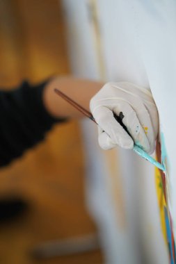 Lastik bir eldiven verin, tuvale boyanmış bir resim yapın.