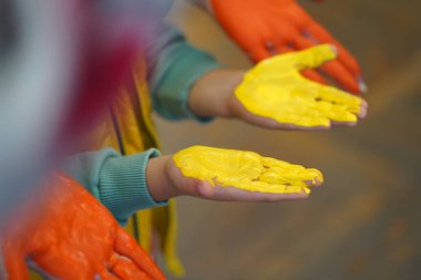 Çocuk sanat okulunda resim dersleri. Fırçalar, eller, boyalar. Çok renkli boyalar içinde çocuk avuçları..