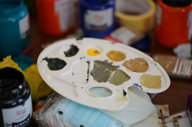 Ressamların ellerinde boyalar olan palet. Lastik eldivenli ve eldivensiz ama çalışmaya hazır..