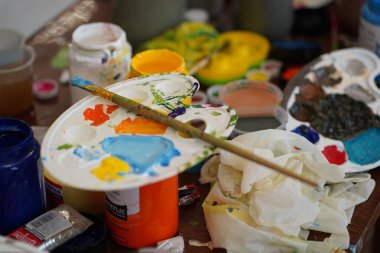 Ressamların ellerinde boyalar olan palet. Lastik eldivenli ve eldivensiz ama çalışmaya hazır..