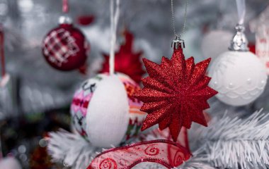 Güzel Noel kırmızı ve gümüşi toplar beyaz bir Noel ağacında. Kurdeleler şeklinde süslemeler ve yazıtlarla Mutlu Noeller ve mutlu yıllar.