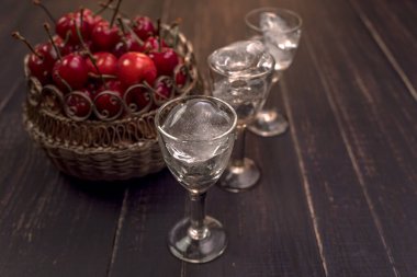 Ahşap bir masada cam yığınları içinde alkollü içecekler. Kiraz, fındık ve limon likörü..