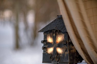 Eski ahşap bir kulübe şeklinde sokak metali bir fener.