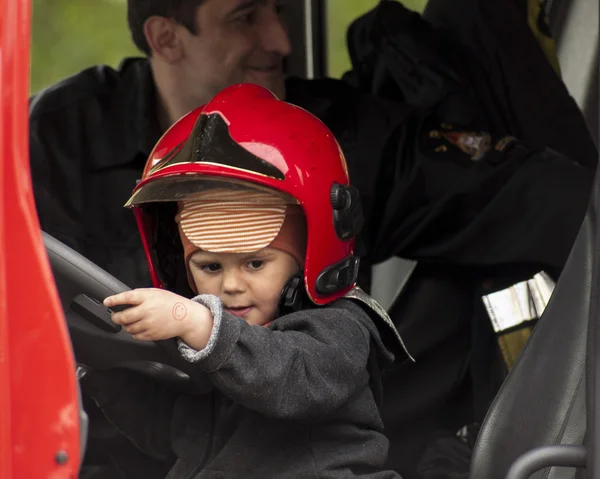 Child in a fireman's helmet in the Fire Truck — Stock Photo, Image