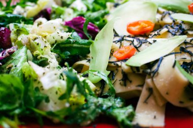 Lezzetli porsiyon tagiatelle makarnası ve üzerine siyah mantar peyniri serpiştirilmiş acı biber. İtalyan baharatlarıyla soslu marul, roka ve peynir çeşitlerinden oluşan bir salata ile servis edilir. Yemek avokado dilimleriyle süslenmiş.. 