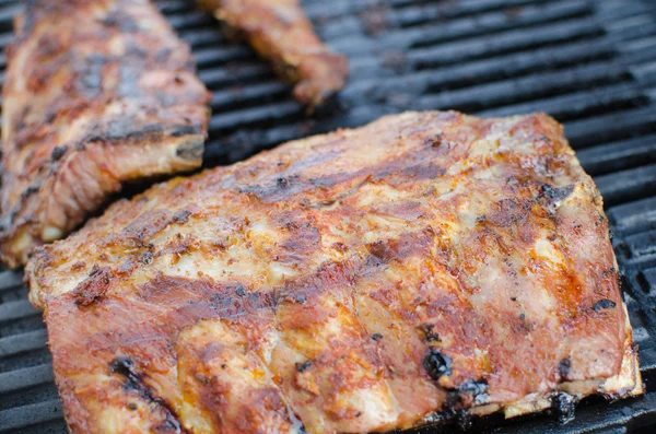 Spareribs on grill with dip and toasted baguette — Stock Photo, Image