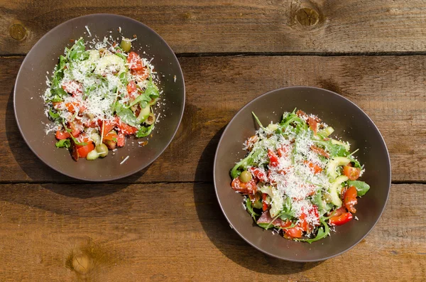 Rucola salade met tomaten, olijven en parmezaanschilfers — Stockfoto