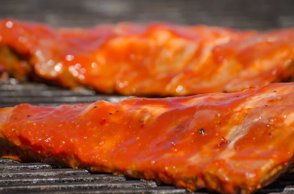 Spareribs on grill with hot marinade — Stock Photo, Image