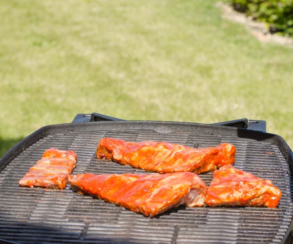 Spareribs on grill with hot marinade — Stock Photo, Image