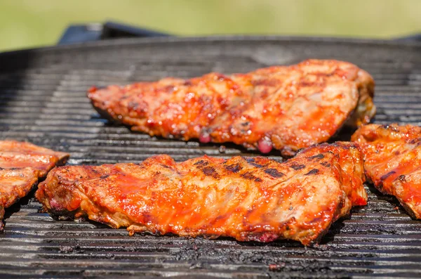 Spareribs on grill with hot marinade — Stock Photo, Image