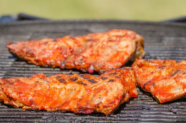 Spareribs on grill with hot marinade — Stock Photo, Image