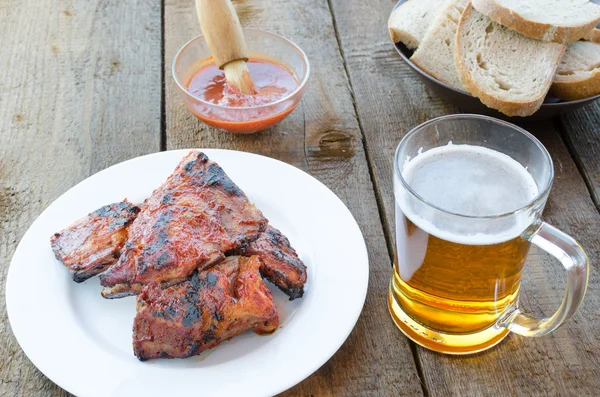 Spareribs on grill with hot marinade, czech beer — Stock Photo, Image