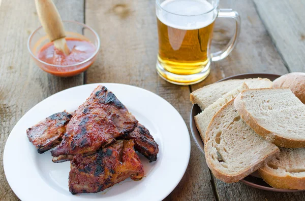 Spareribs on grill with hot marinade, czech beer — Stock Photo, Image