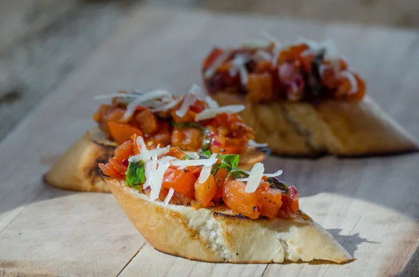 Crostini con cebolla, tomate y albahaca —  Fotos de Stock