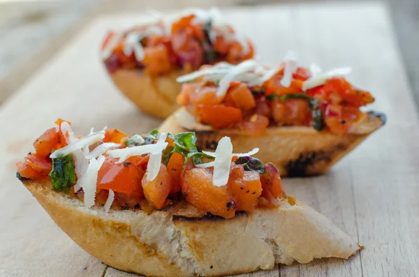 Crostini med lök, tomat och basilika — Stockfoto