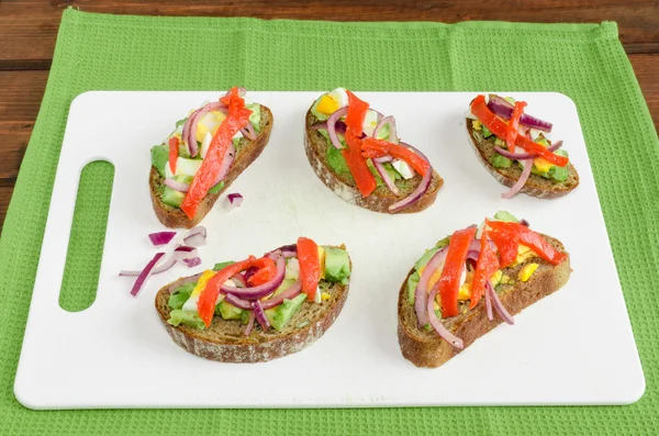 Braunes Brot mit Avocado, Räucherlachs, gekochtem Ei — Stockfoto